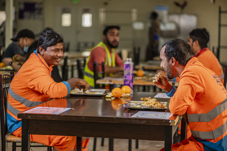 عمال يتناولون أحد وجباتهم داخل قاعة الطعام في مكان سكنهم بالقرب من استاد لوسيل